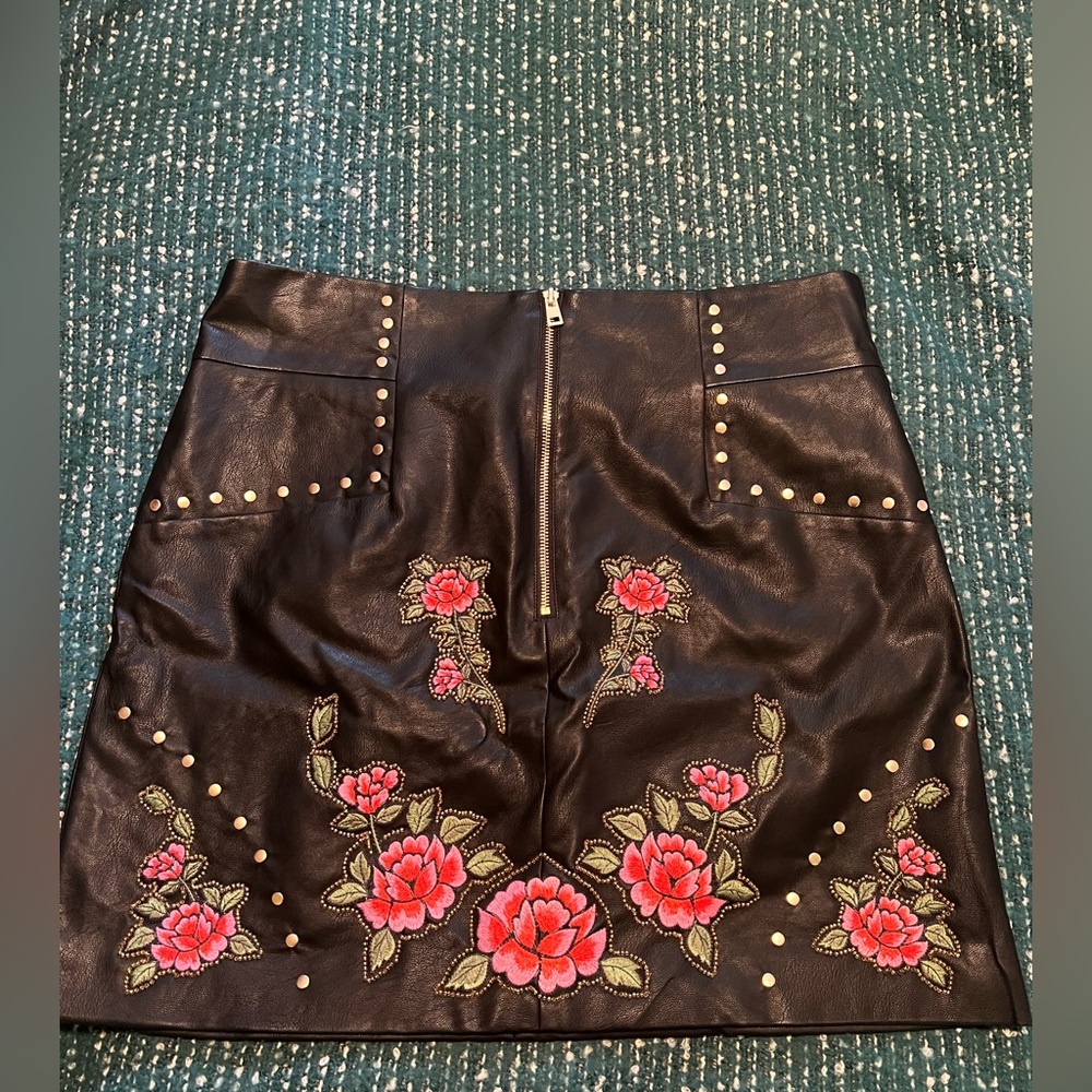 Short leather skirt with flower detail on the front with beads.